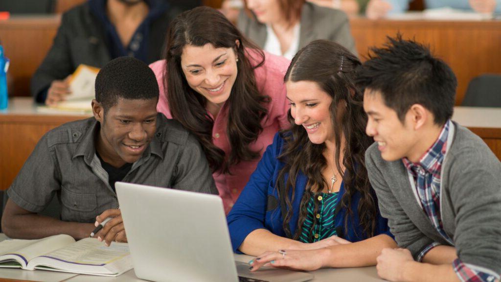 Group of diverse students and their teacher learning new concepts