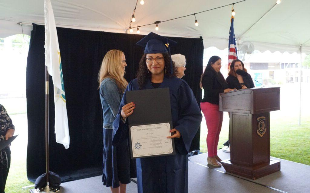 Woman showing her diploma at graduation